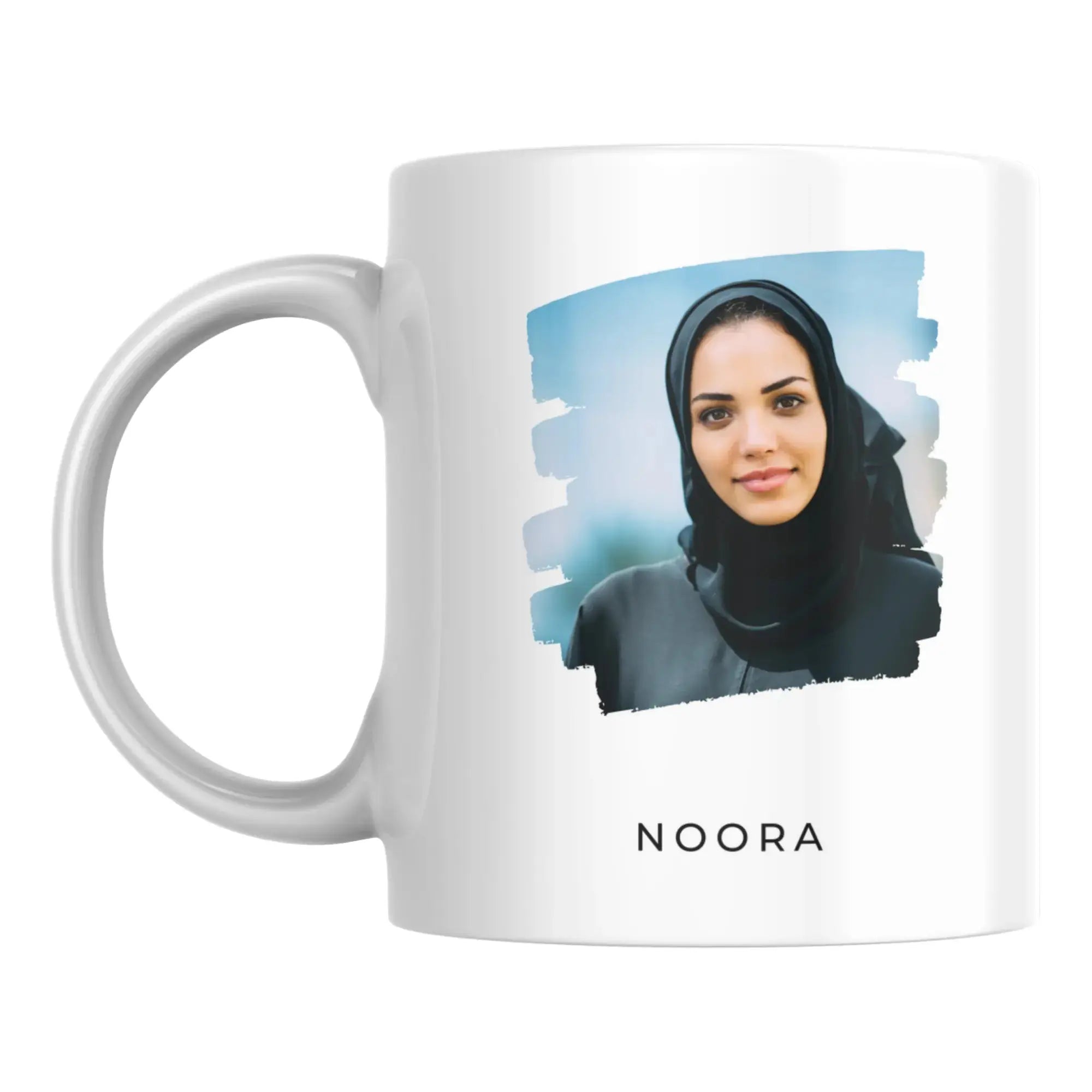 White mug with a photo of a woman wearing a hijab and the name 'NOORA' on a white background